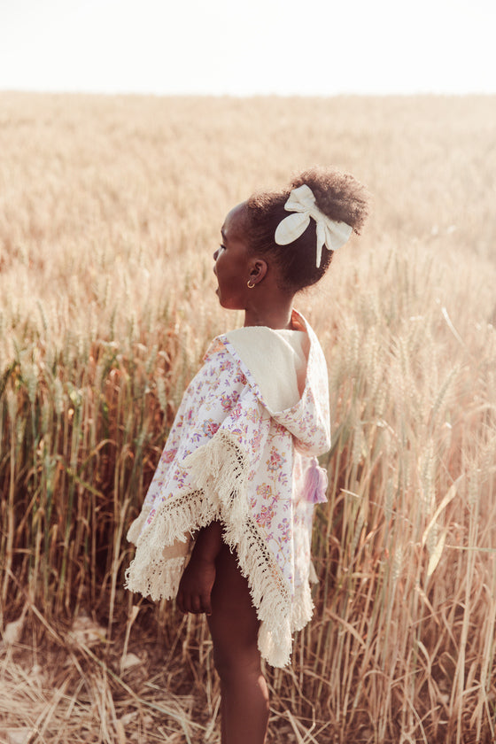 The Mael beach cape in Cream Bucolia Fields print is made with organic cotton, which is very soft and absorbent. This girl's beach cover-up is made with organic cotton and is soft inside by Louise Misha. The best gift for baby shower, present for babies and also present for kids. Shop the widest summer clothing online.