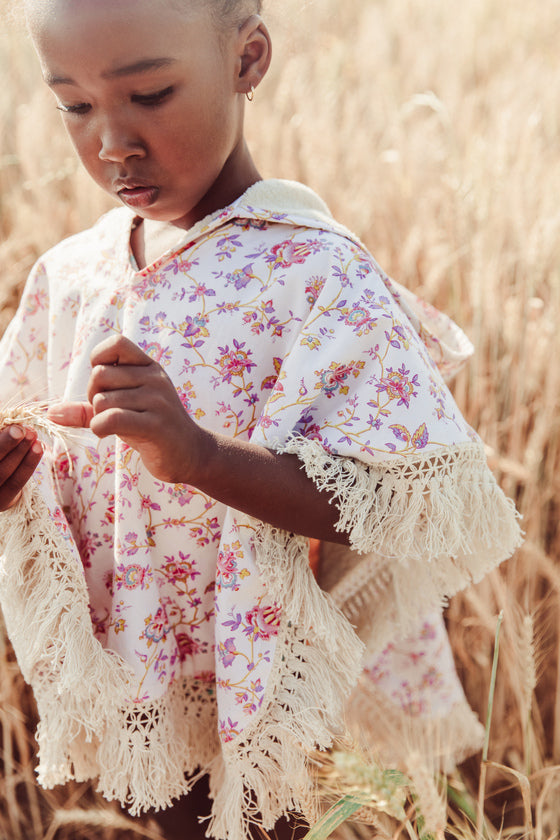 The Mael beach cape in Cream Bucolia Fields print is made with organic cotton, which is very soft and absorbent. This girl's beach cover-up is made with organic cotton and is soft inside by Louise Misha. The best gift for baby shower, present for babies and also present for kids. Shop the widest summer clothing online.