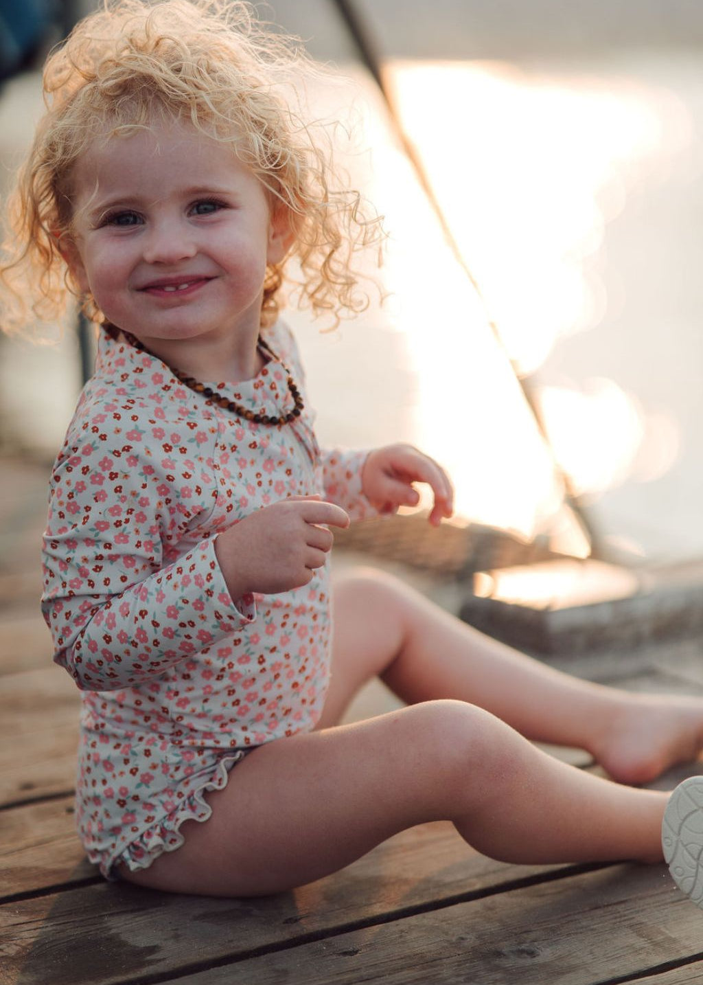 Detail of zipper pocket and ruffle accents on Sunset Meadow girls' swimsuit