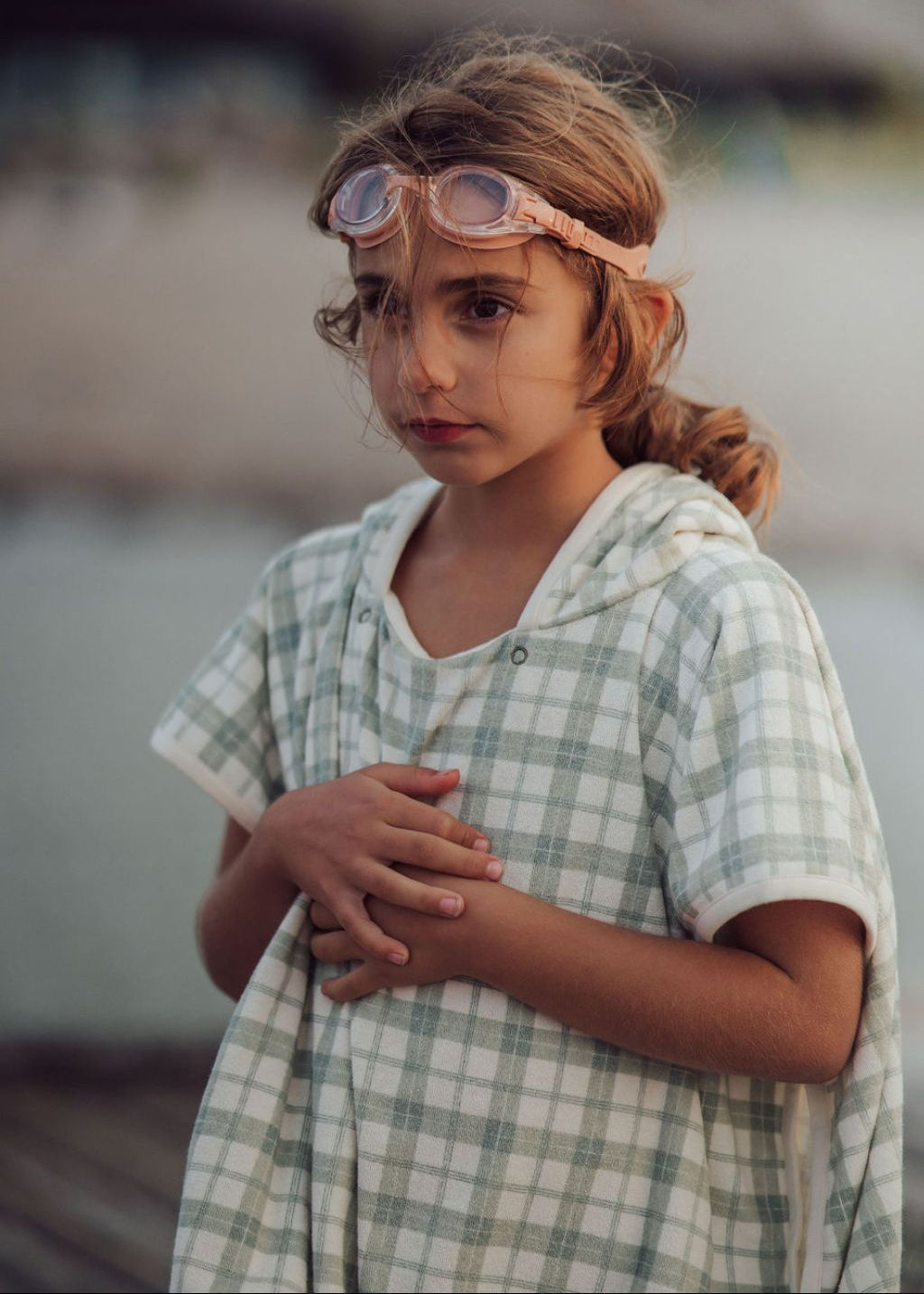 Child wearing organic cotton fern plaid beach poncho with hood and side buttons