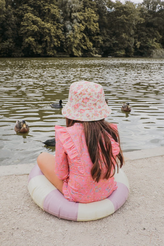 Sustainable girls swimsuit in pink flower pnrint. This girls long sleeve swimsuit is made from SPF 50 protective and recycled fabric designed by Louise Misha.