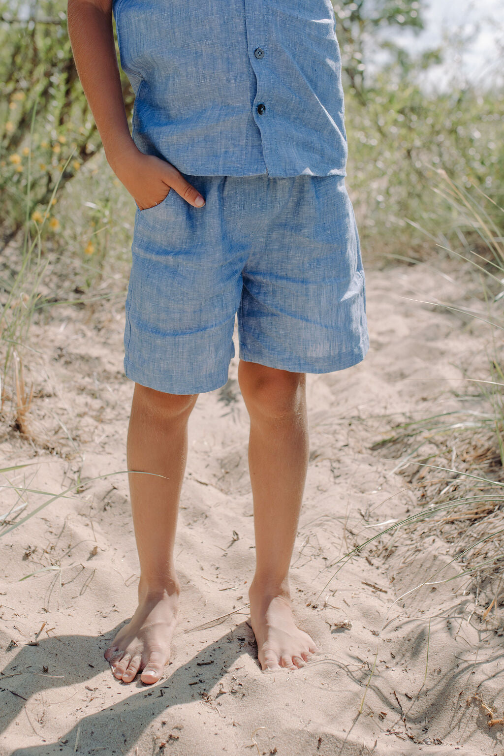 Breathable blue linen shorts for boys, detail view showing premium fabric quality and pockets.