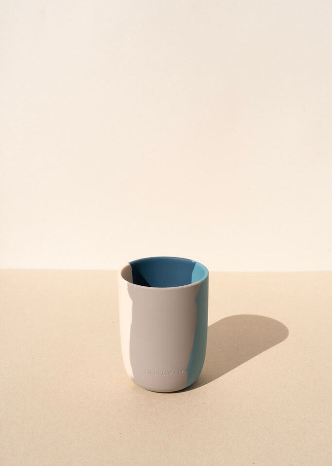 Grech & Co blue silicone toddler cup on warm beige background showing two-tone stone and teal design — eco-friendly kids cup at Milimilu