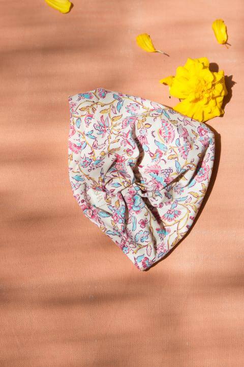 The popular girl turban in padma flower, made from an SPF 50 protective fabric in a turban-style swim cap by Louise Misha. Shop sustainable kids swimswear.
