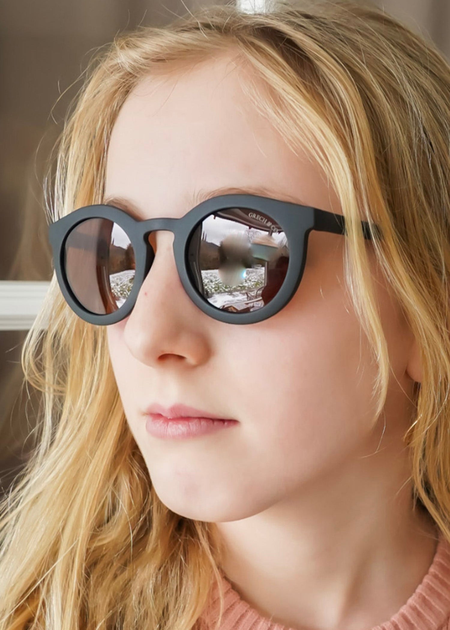 Close up of sustainable kids black sunglasses showing plant-based bendable frame design