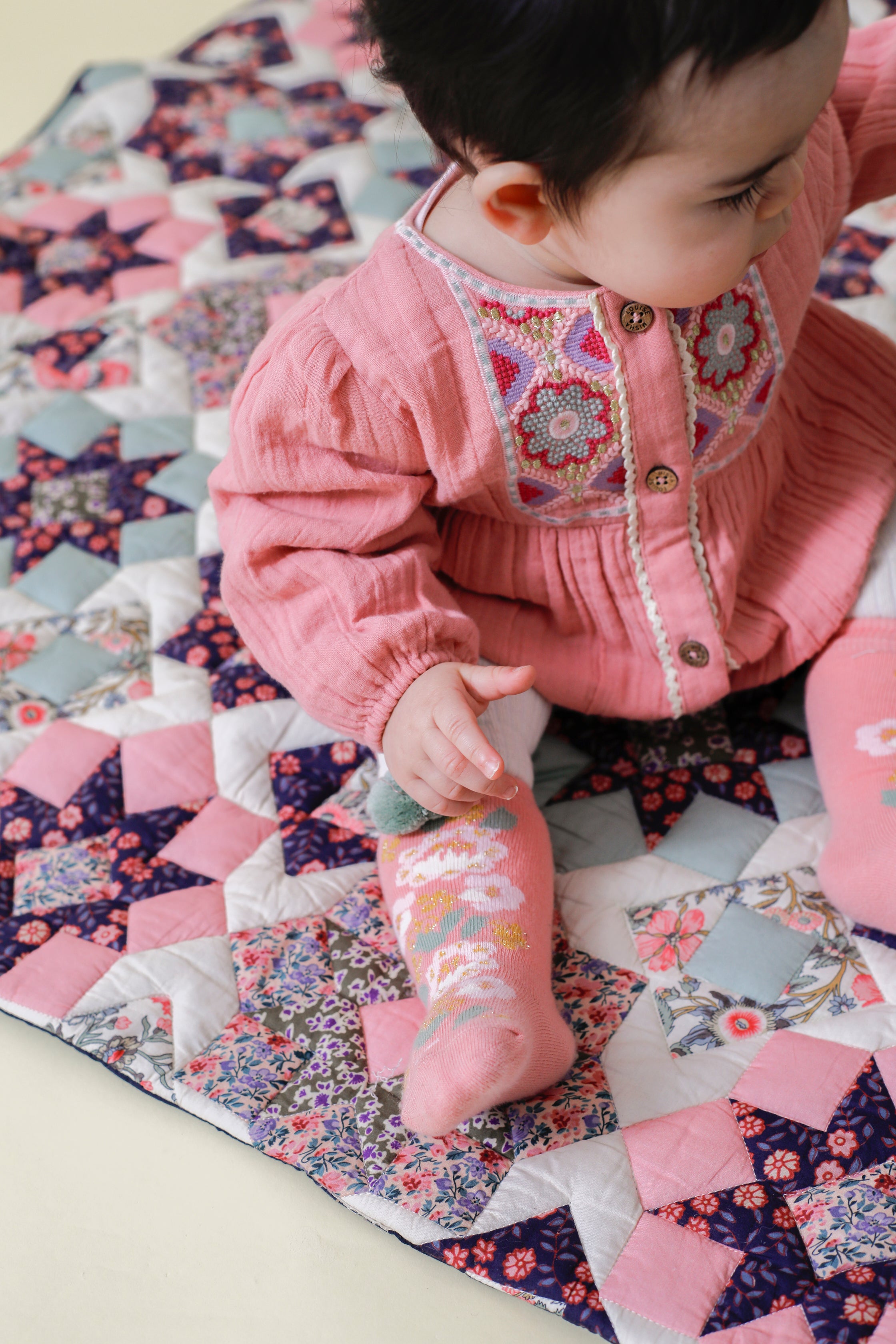 This pink romper for baby girls with embroideries is made with soft organic muslin, using organic cotton (GOTS) by Louise Misha. The best baby gift & presents.
