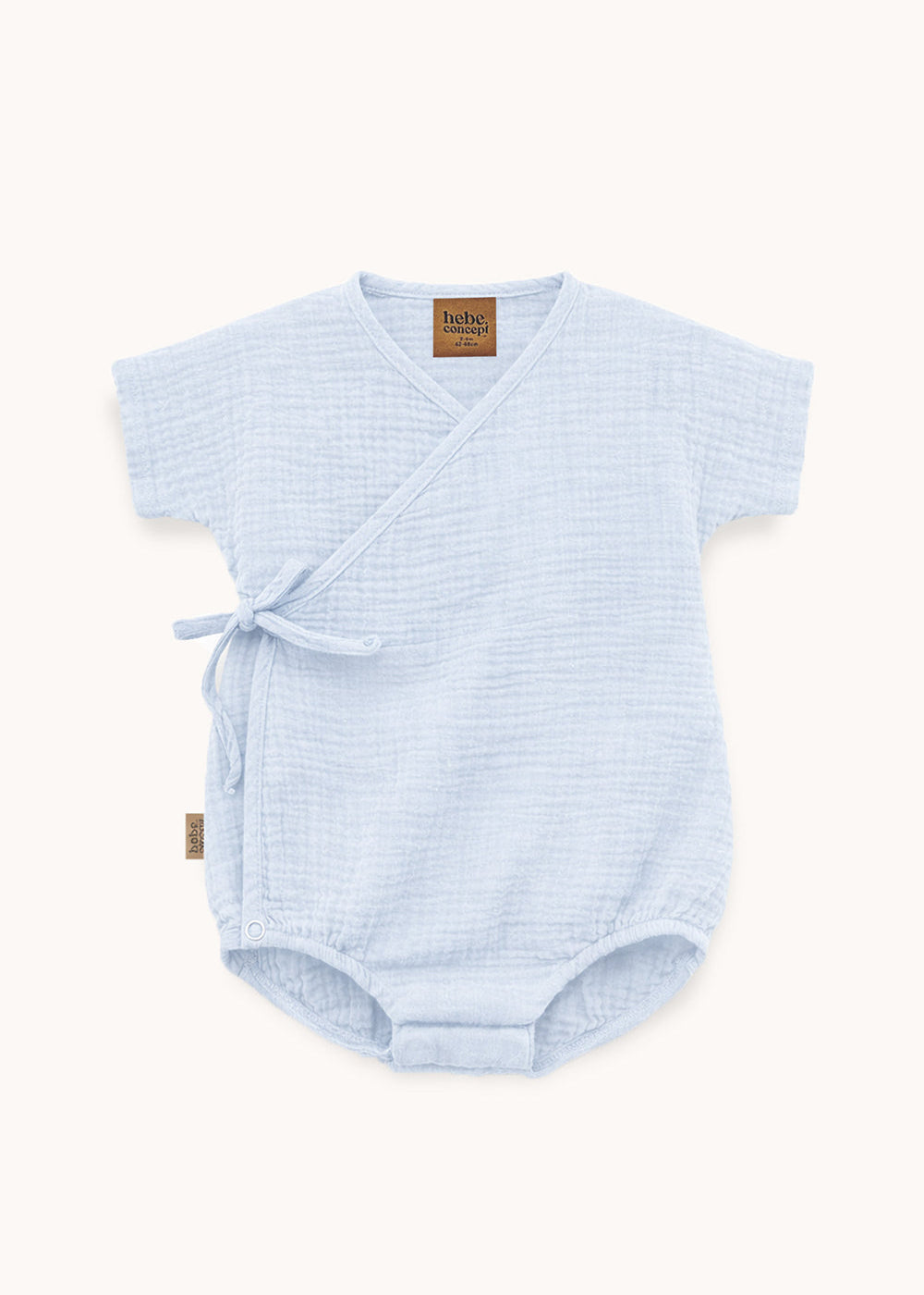 Flat lay of light blue muslin wrap baby bodysuit – GOTS certified organic cotton, wrap-front design