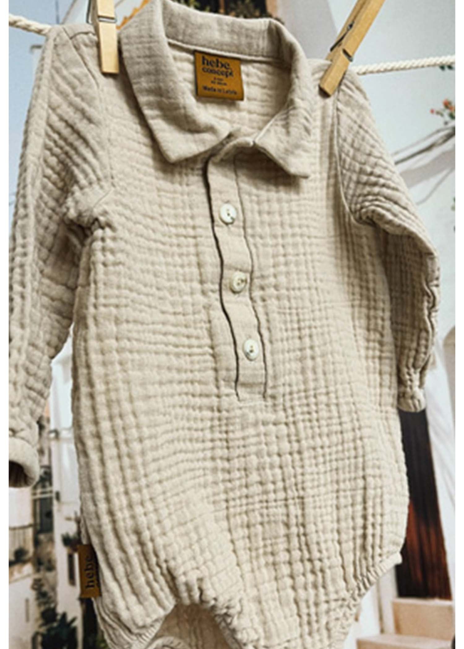 Organic baby muslin romper in light grey, front view showing soft collar and snap closure.