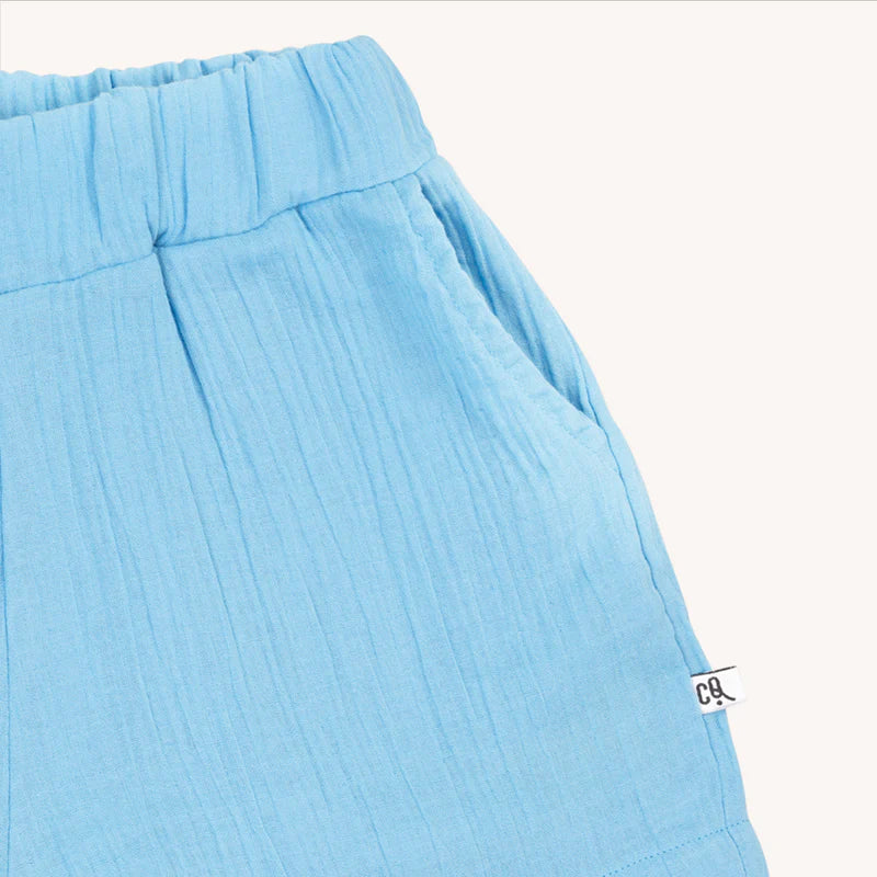 Shop organic muslin fashionable girl shorts with a light blue base and pockets online at MiliMilu. They are made with organic cotton muslin, which is breathable and extra light for wear during the hotter summer months! Milimilu offers the best summer clothing for hot and humid weather. Best gifts and presents for kids.