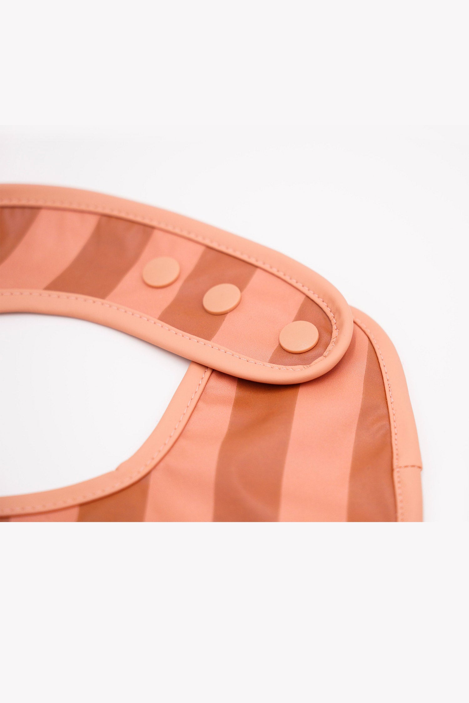 Grech & Co. easy-to-clean and store pink bib. Bib with pocket and water-resistant recycled oeko tex material. Practical and stylish sustainable baby pink bib.