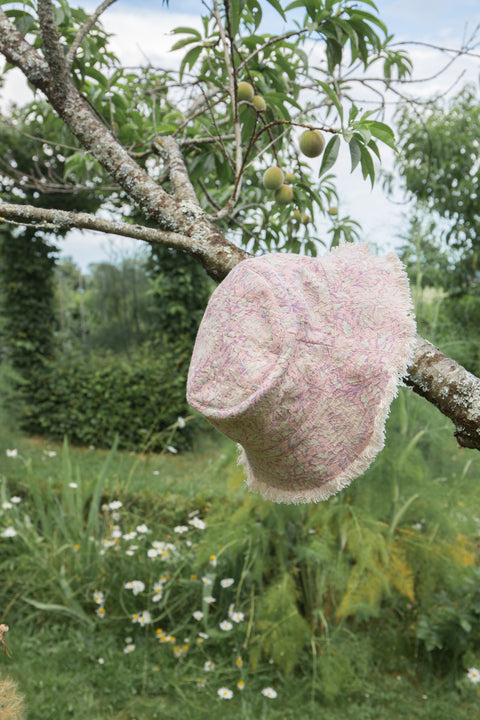 Our kid's bucket sun hat, which is not only lightweight and stylish but also comes in a beautiful print that your child will love. On one side, you have a charming pink daisy garden print, and on the other side, an off-white colour with a fringed edge. Designed by Louise Misha. Mini Me matching is available.