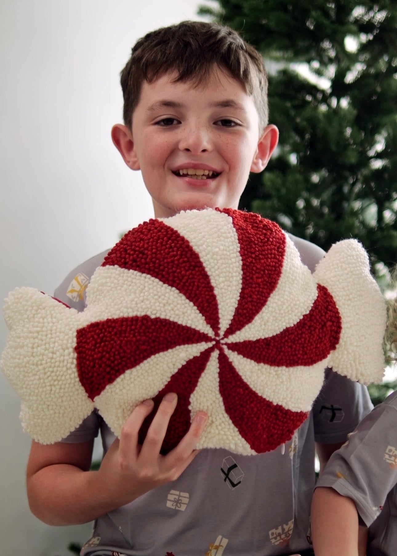 Boy wearing organic bamboo Christmas t-shirt holding festive toy, hypoallergenic kids holiday tee