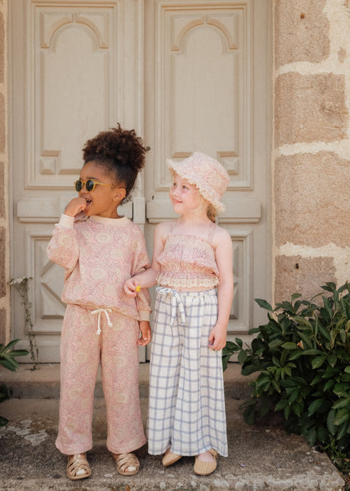 Baby wearing Louise Misha Lajik sun hat - pink daisy garden print bucket hat for sun protection