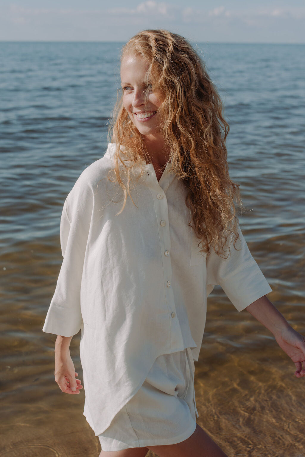 Womens off white linen shorts styled with matching linen shirt, complete sustainable summer outfit.