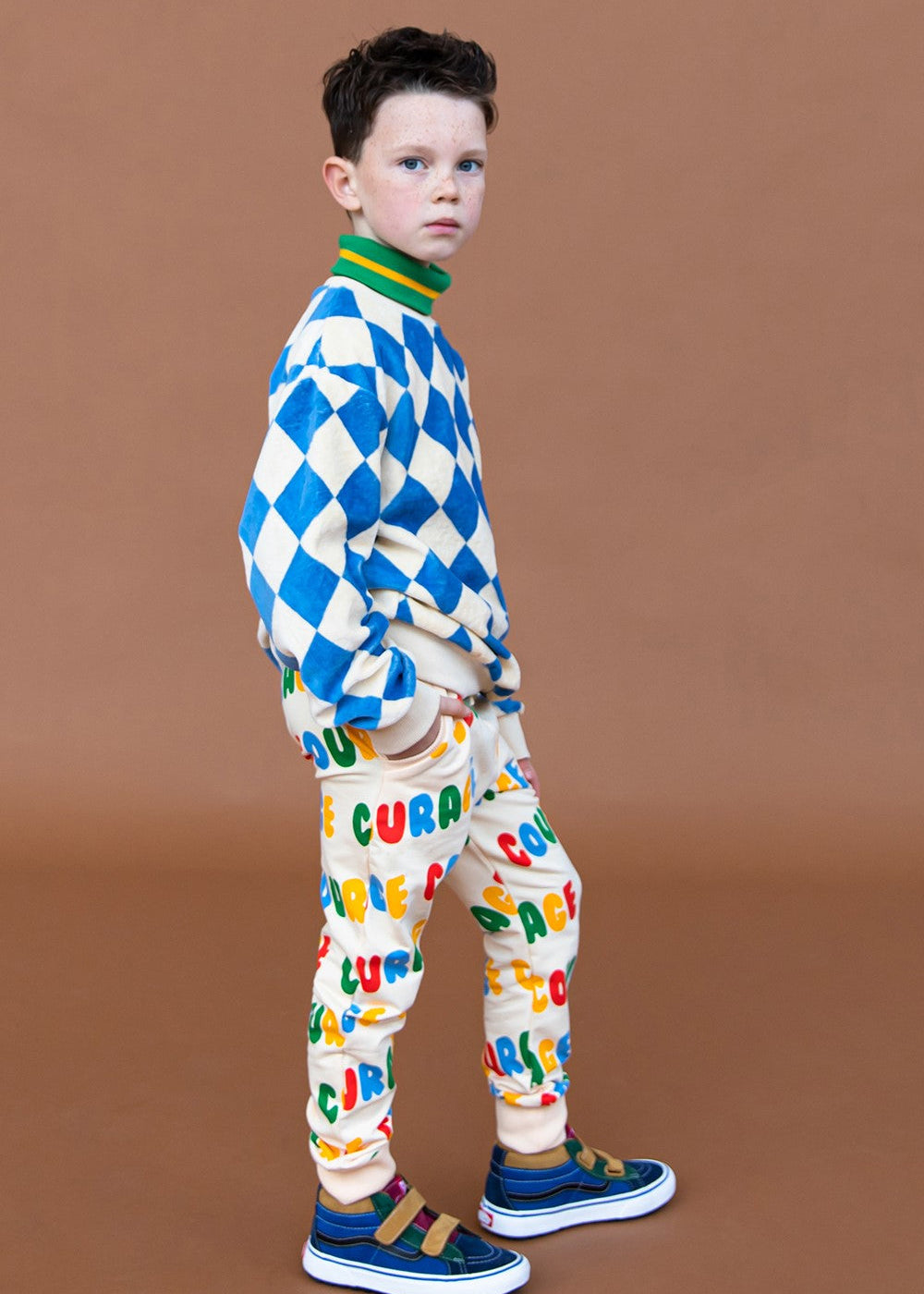 Kids organic cotton sweatpants with colourful Courage print — side view showing relaxed fit