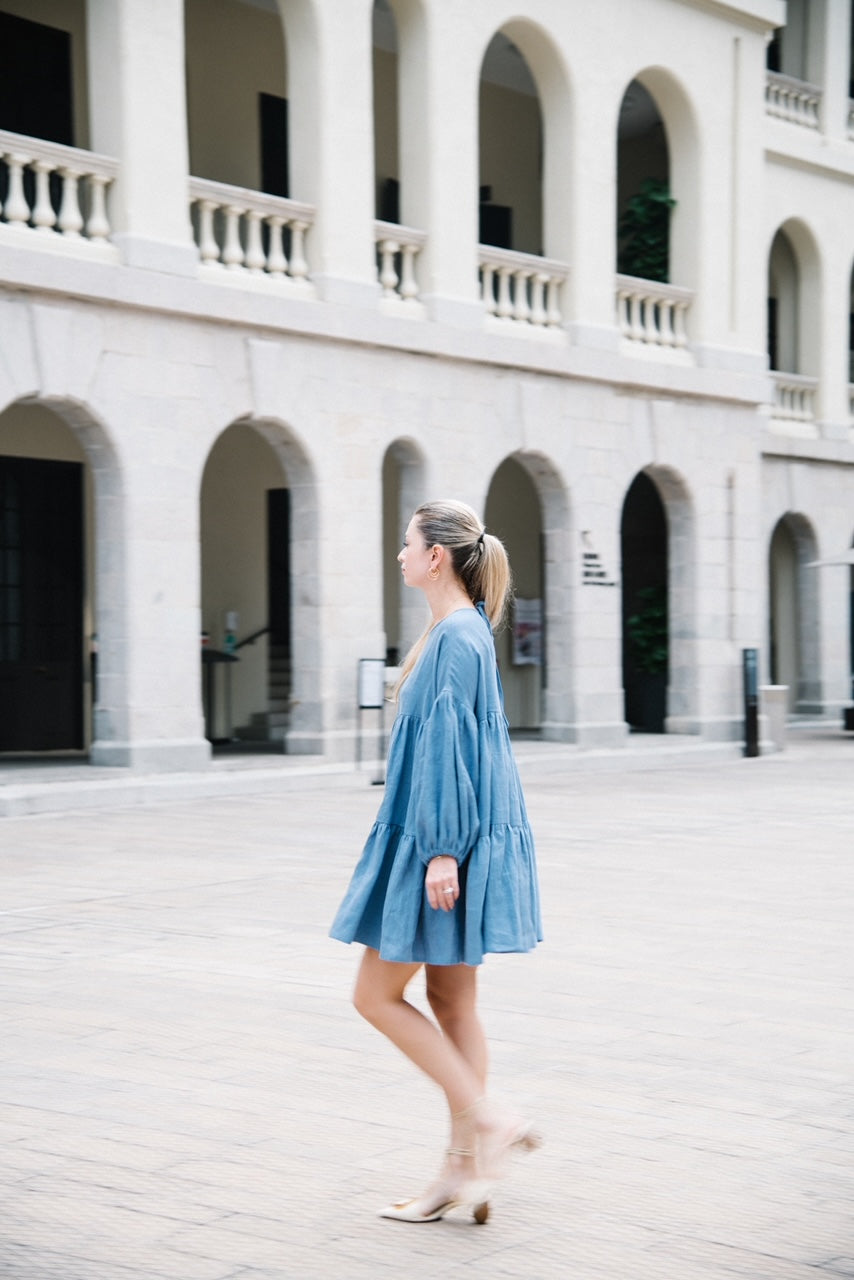 Slow fashion women's linen dress in french blue color with long voluminous sleeves made from pure linen in a loose fit. Timeless women's dress for creating a capsule wardrobe. The dress is handmade from 100% European flax. MiliMilu offers high quality affordable linen fashion and clothing for women and men in Hong Kong