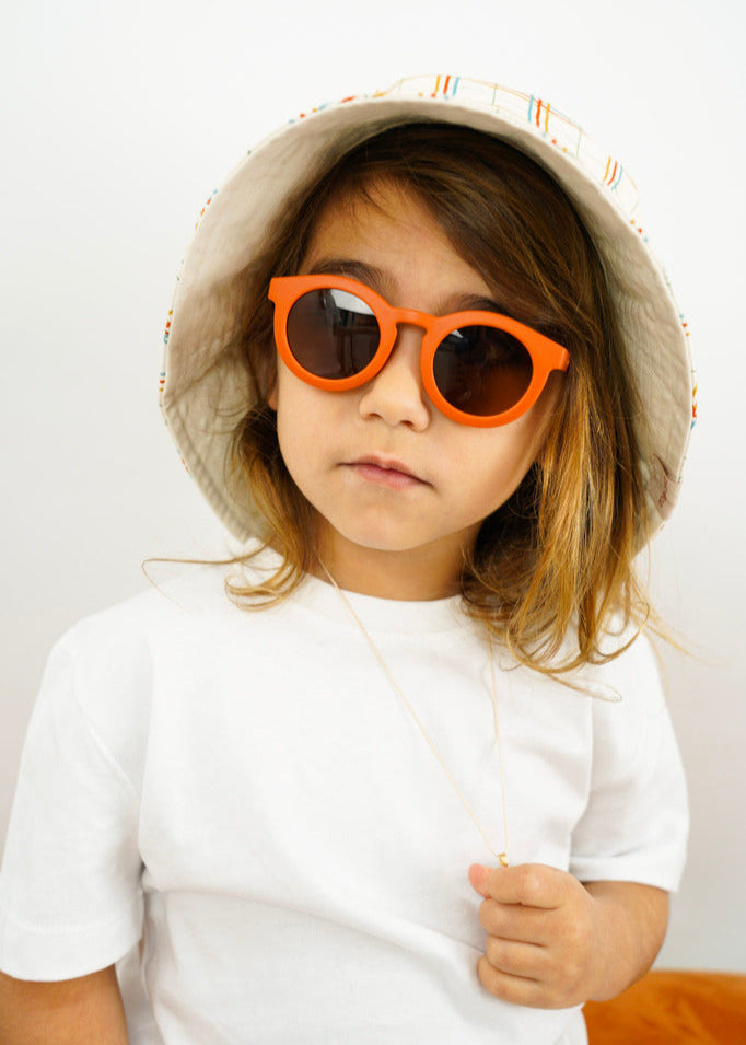 Sustainable sunglasses in orange by Grech & Co are eco-friendly/non-toxic break-resistant material with polarised lenses and UV400 protection. Best kids gift.