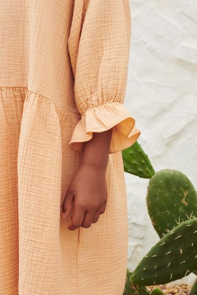 The breathable organic cotton girl's muslin dress in toast colour. MiliMilu Lifestyle offers organic cotton kids clothing and organic cotton girl dresses.
