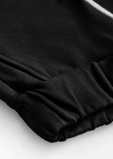 Child wearing Dear Sophie black organic cotton joggers comfortable kids trousers