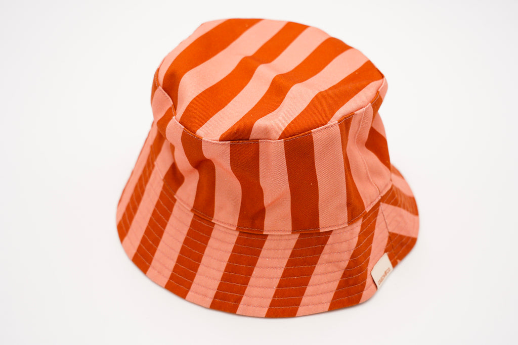 Shop kid's hats and kids summer hats online in Hong Kong and Singapore. Stylish kid's bucket hat with pink and red stripes will make sure you are protected from the sun while being stylish, made with 100% Certified Organic Cotton (GOTS) -  gentle to the skin. It is also a reversible kid's bucket hat to keep you in style.