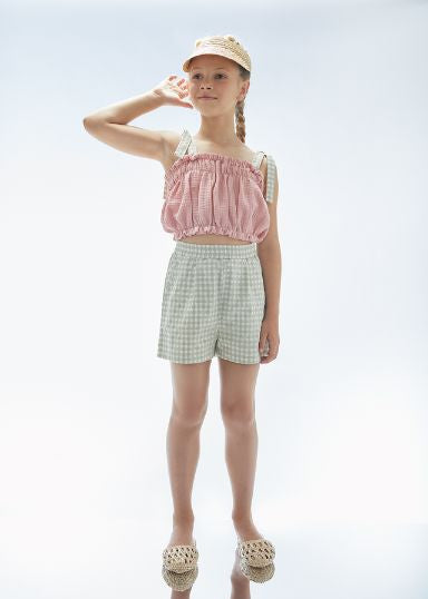 Child wearing Jellymade Isla tea green check shorts organic cotton sustainable kids fashion.