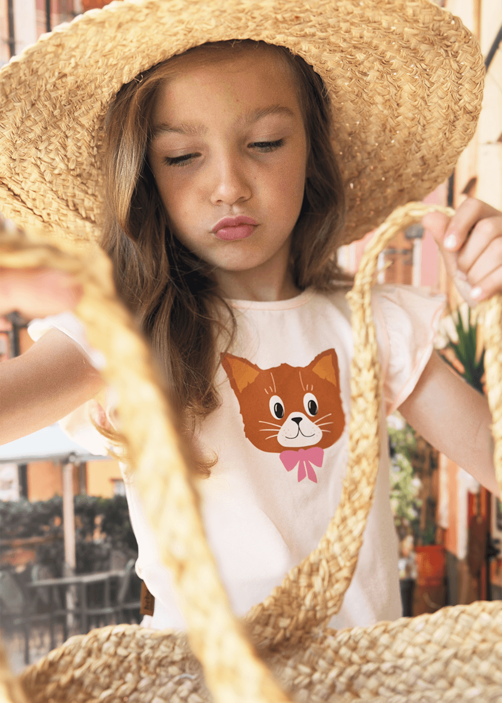Close-up of cat face print with pink bow on ruffle cotton top – GOTS certified organic girls clothing