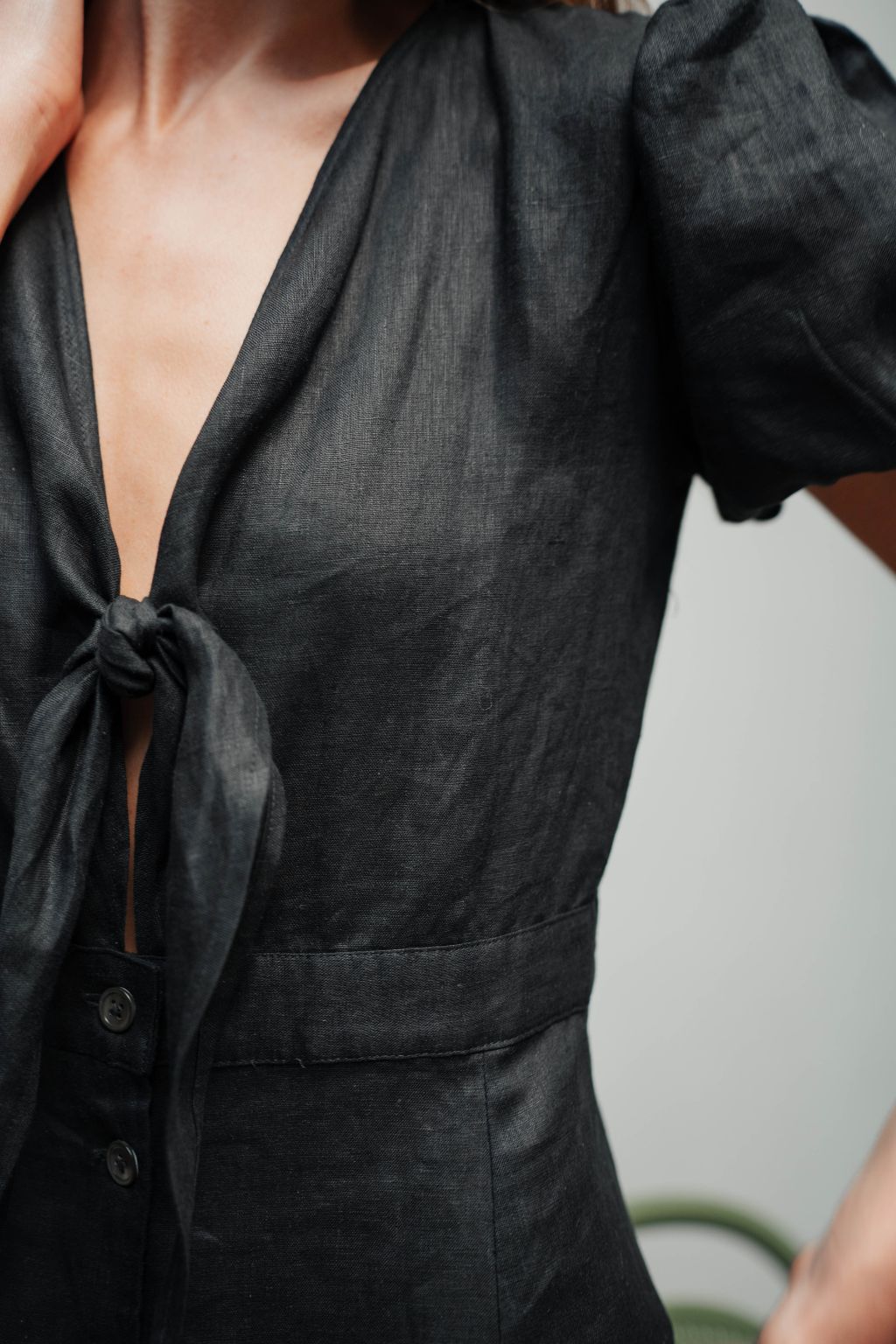Black linen dress with front tie knot detail and shell buttons.