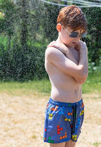 Shop boys BLOX Swim Shorts! These ultra-colorful shorts feature a blue base with a BLOX print and an elastic waistband with a drawstring. Made with 100% reprieve recycled polyester, these boys' swim trunks from kids to tween size trunks are not only comfortable and soft for everyday wear but also popular.