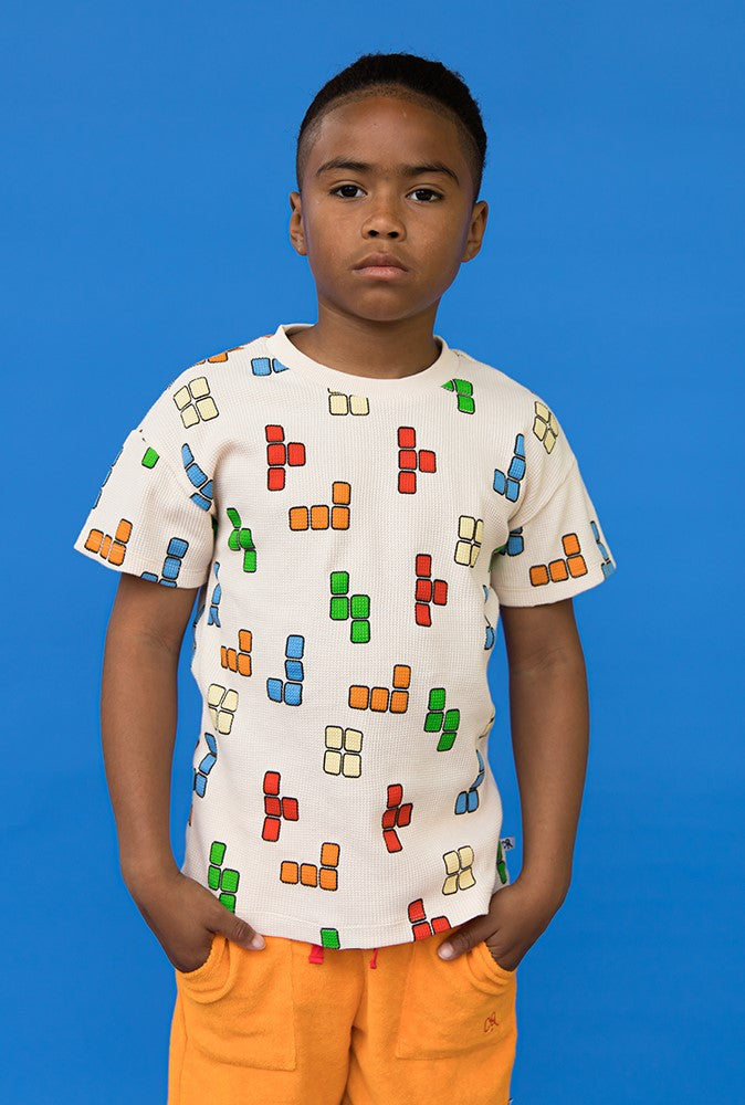 Shop the Blox Crewneck White T-Shirt is a must-have for every kid's wardrobe. With its classic Tetris-style print t-shirt it's perfect for game-loving kids. Tailored for boys and teenagers, the collection offers a vibrant array of colors to ensure they stand out - unique kids clothing. Organic cotton t-shirt for kids.