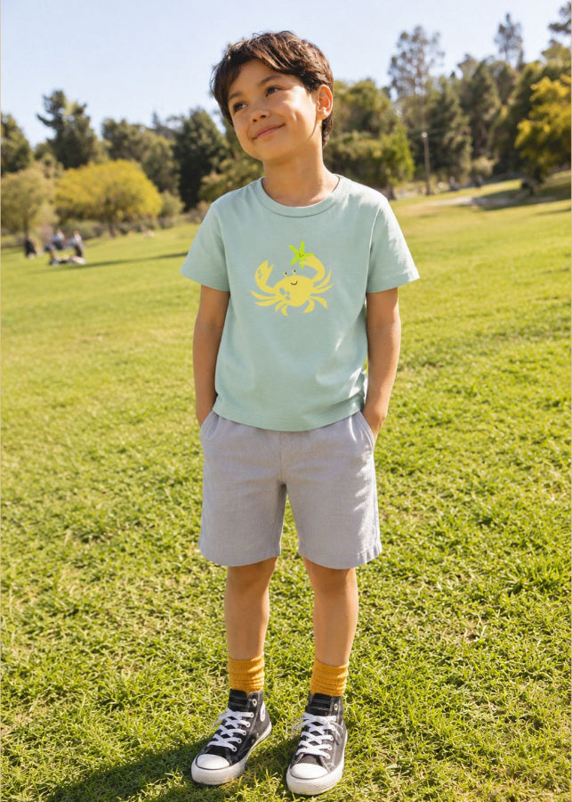 Child wearing a light blue t-shirt with a crab print, organic cotton kids clothing
