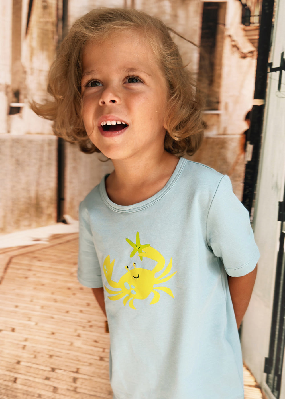 Close-up of yellow crab print on aqua blue kids T-shirt – soft breathable cotton by Milimilu