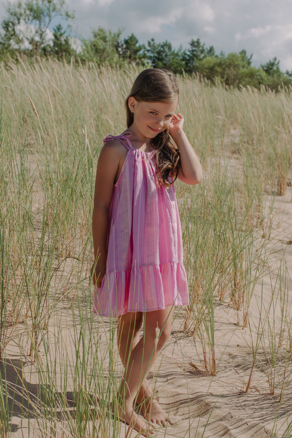 Girl wearing pink Lilly print summer dress, comfortable, sustainable kids fashion.