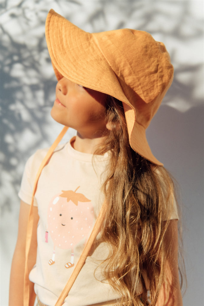 Shop breathable and stylish linen girl's sun hat in organge colour for summer and also for sun protection. Made from high-quality European linen without any harmful chemicals by Hebe in fair trade. MiliMilu offers sustainable kids' fashion and accessories Hong Kong and Singapore's best girls' summer hats.
