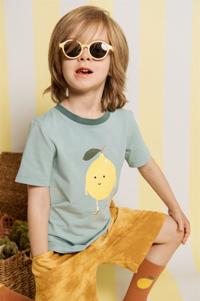 A breathable, organic cotton kid's summer t-shirt with lemon print is comfortable, practical and stylish. Made from fabric that is soft but durable, without harmful chemicals in fair trade in Latvia. Milimilu offers sustainable kids' and teen clothing from organic materials, the best clothing for hot and humid weather.