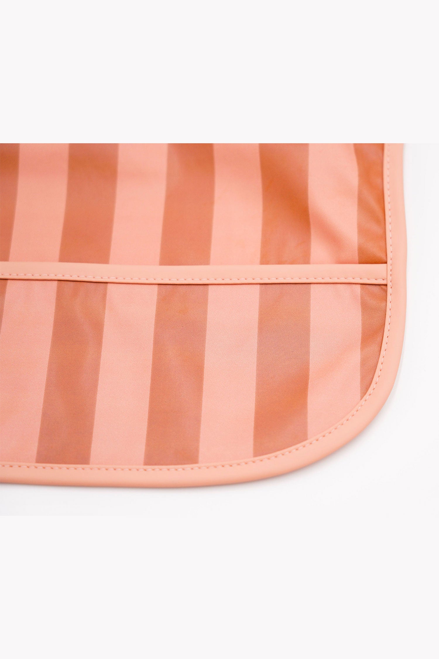 Grech & Co. easy-to-clean and store pink bib. Bib with pocket and water-resistant recycled oeko tex material. Practical and stylish sustainable baby pink bib.