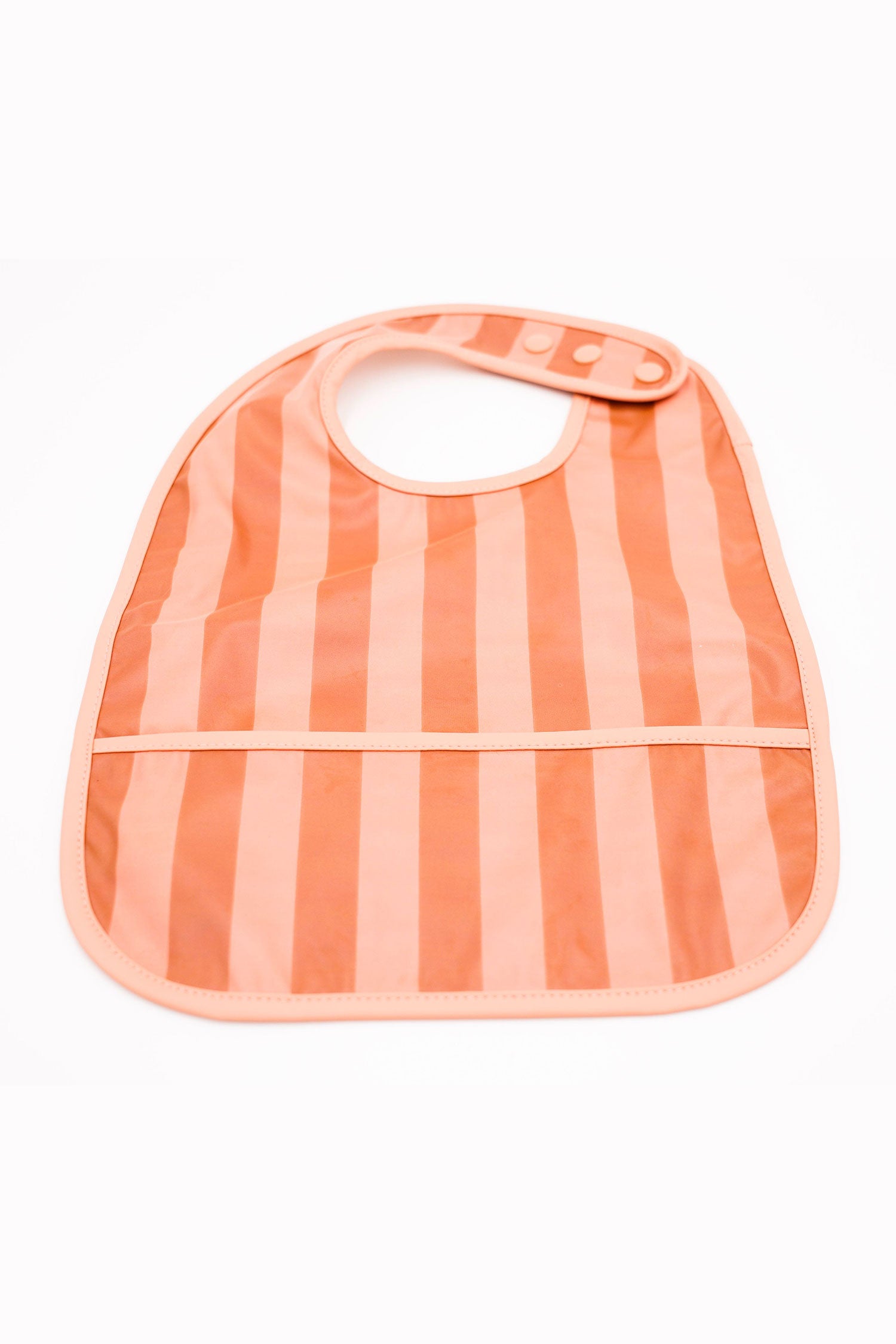 Grech & Co. easy-to-clean and store pink bib. Bib with pocket and water-resistant recycled oeko tex material. Practical and stylish sustainable baby pink bib.