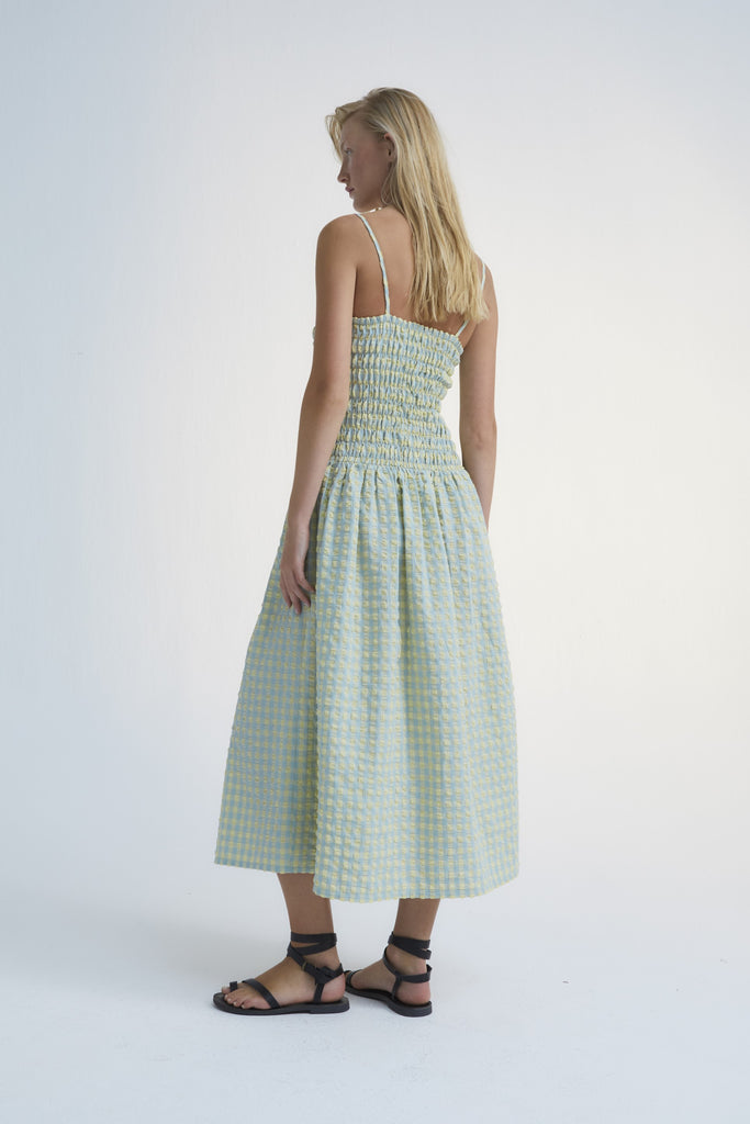 Shop Canyon women's summer maxi dress, which is one of the trendiest summer dresses and the perfect addition to your capsule wardrobe. The checked women's summer dress is designed with straps, pockets, and smock top. The most stylish summer dress you will have this summer. Shop best women summer fashion online.