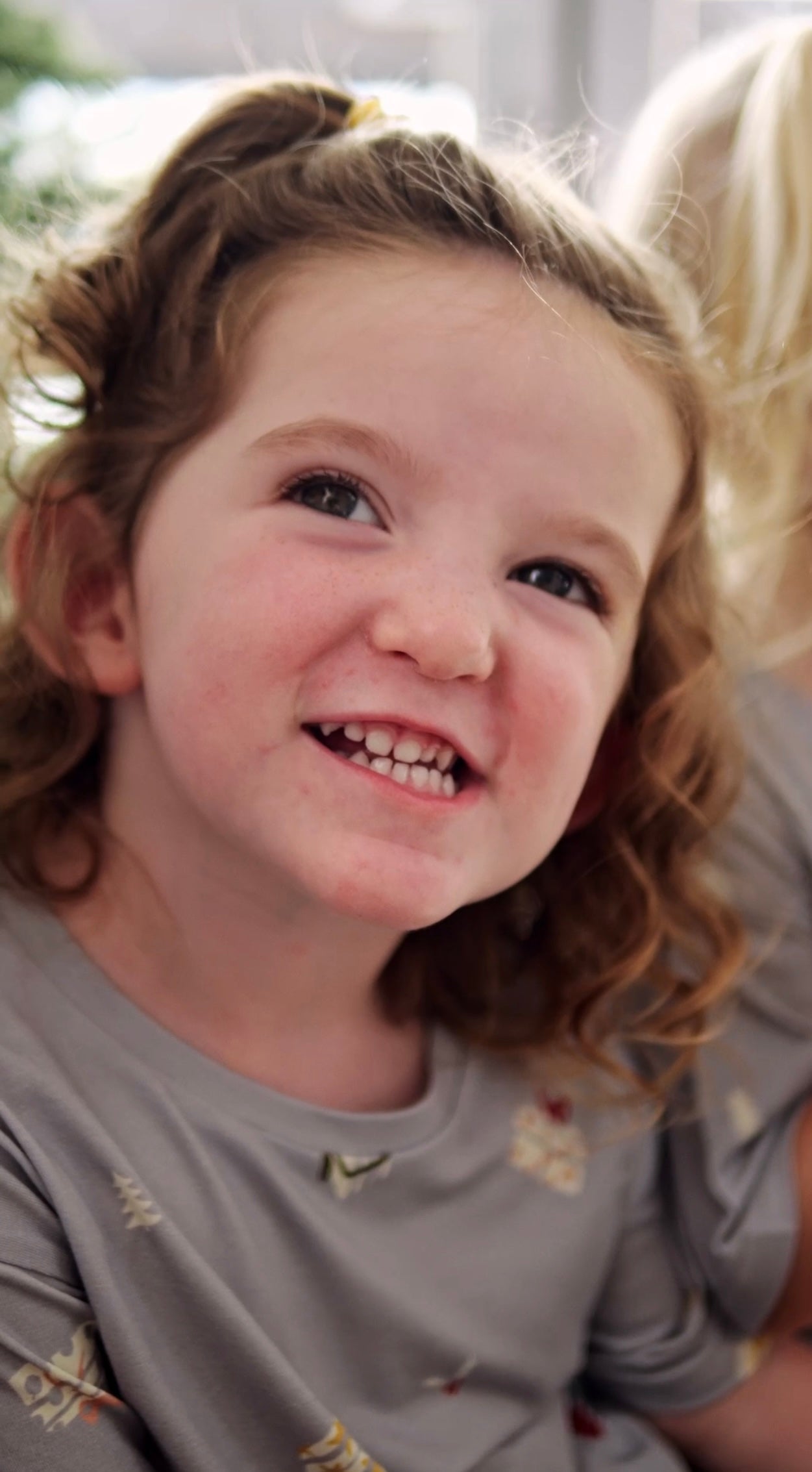 Girl smiling wearing sustainable bamboo Christmas t-shirt with Love of Gifting design, eco-friendly kids holiday clothing