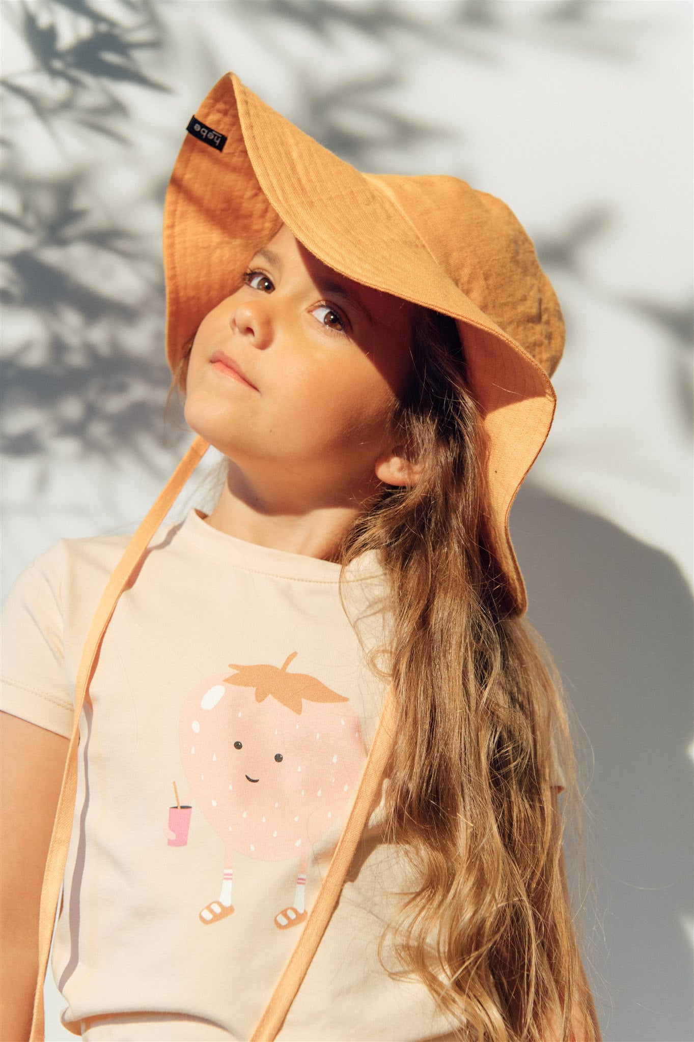 Breathable and stylish linen girl's sun hat in organge colour for summer and also for sun protection. MiliMilu offers sustainable kids fashion and accessories.