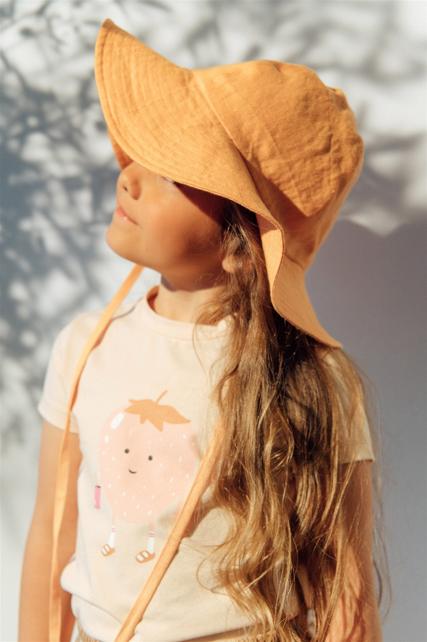 Breathable and stylish linen girl's sun hat in organge colour for summer and also for sun protection. MiliMilu offers sustainable kids fashion and accessories.