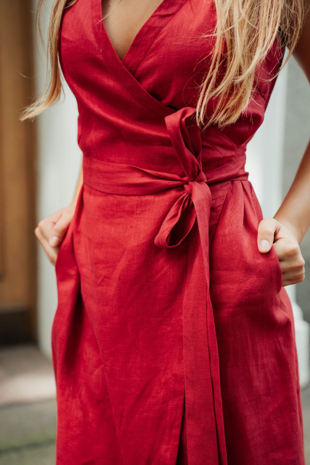 Linen wrap dress with functional side pockets in garnet red.