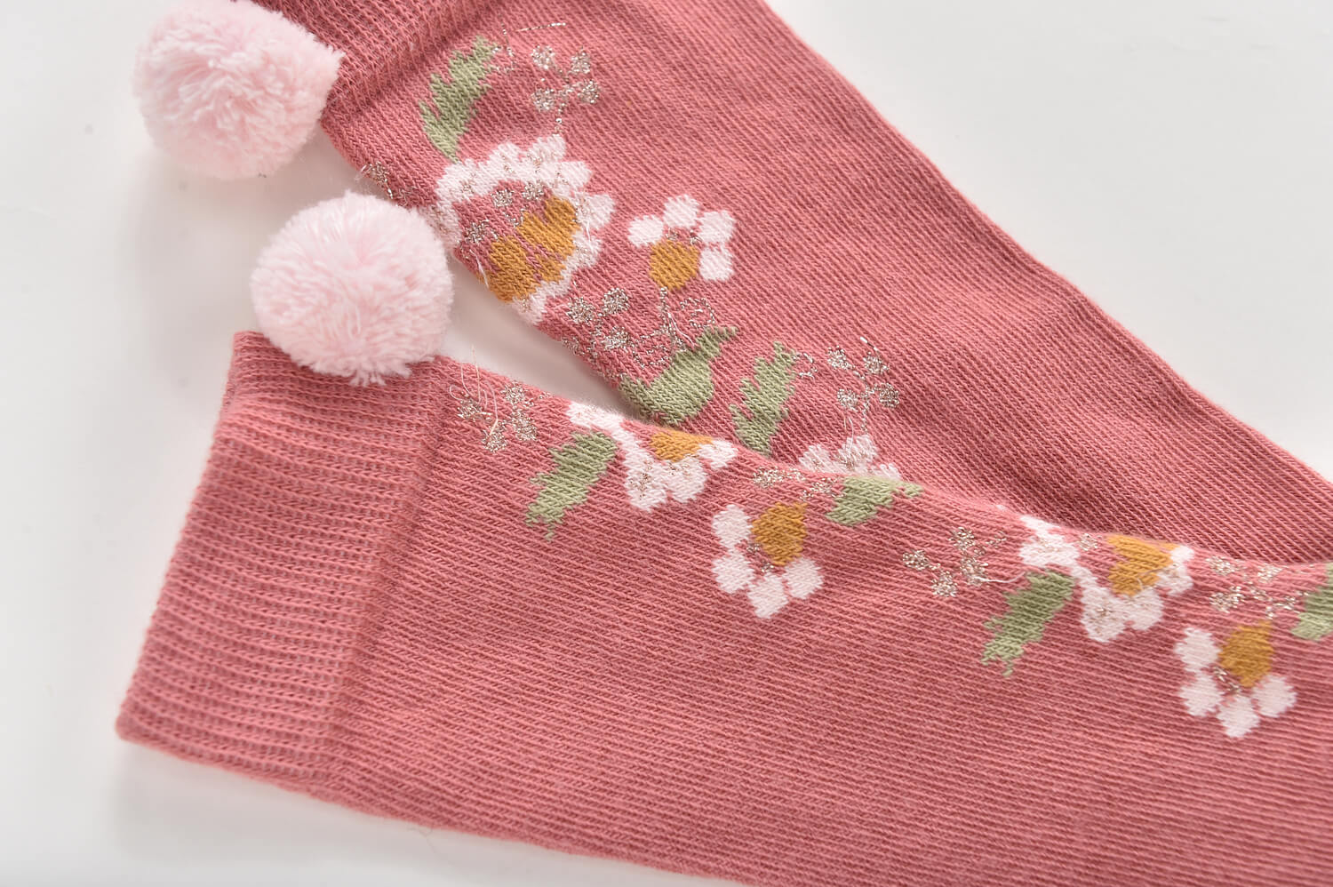 For every outfit, it's essential to have cute socks, and the Sienna socks in pink with floral patterns and handmade pompoms by Louise Misha.