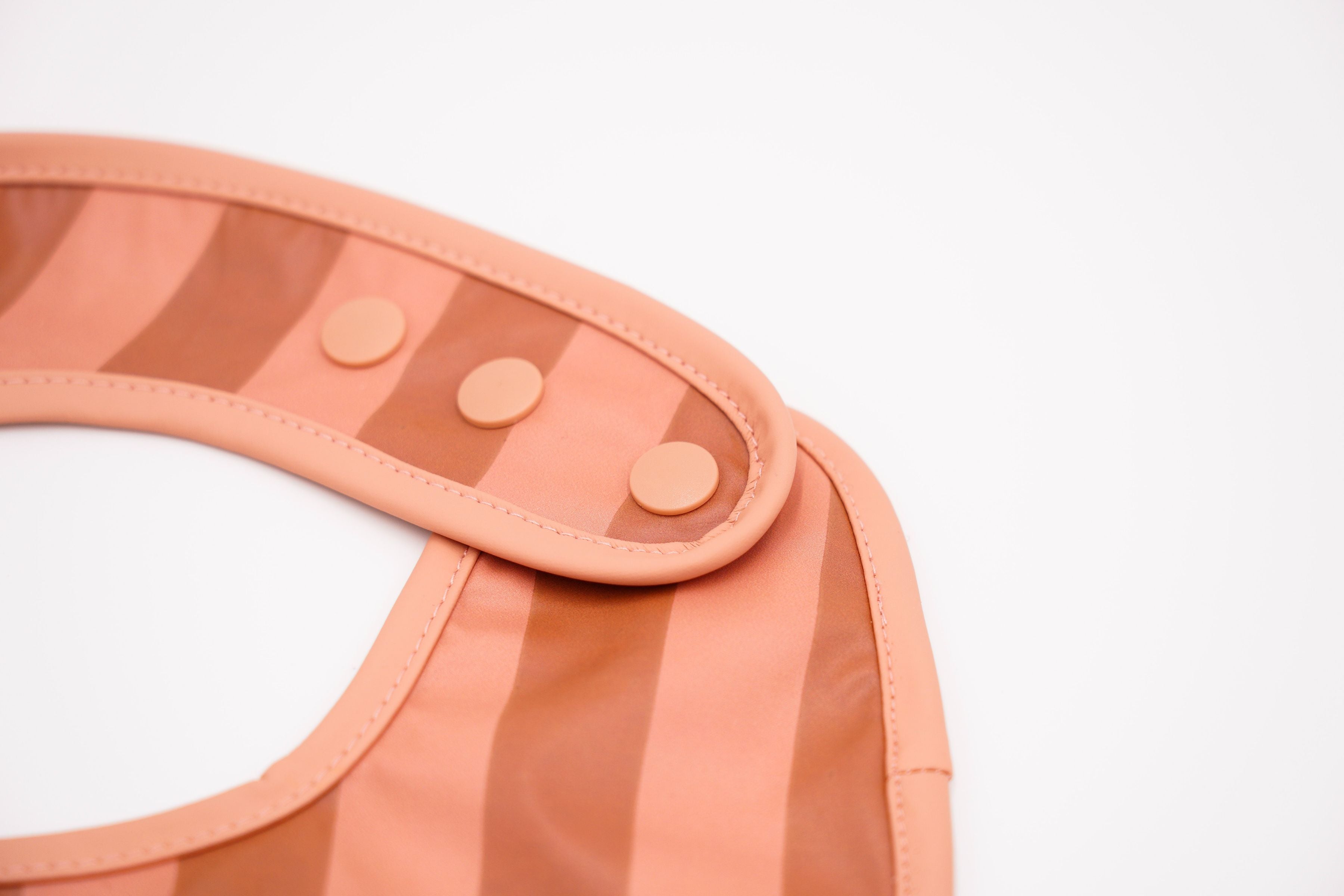 Grech & Co. easy-to-clean and store pink bib. Bib with pocket and water-resistant recycled oeko tex material. Practical and stylish sustainable baby pink bib.