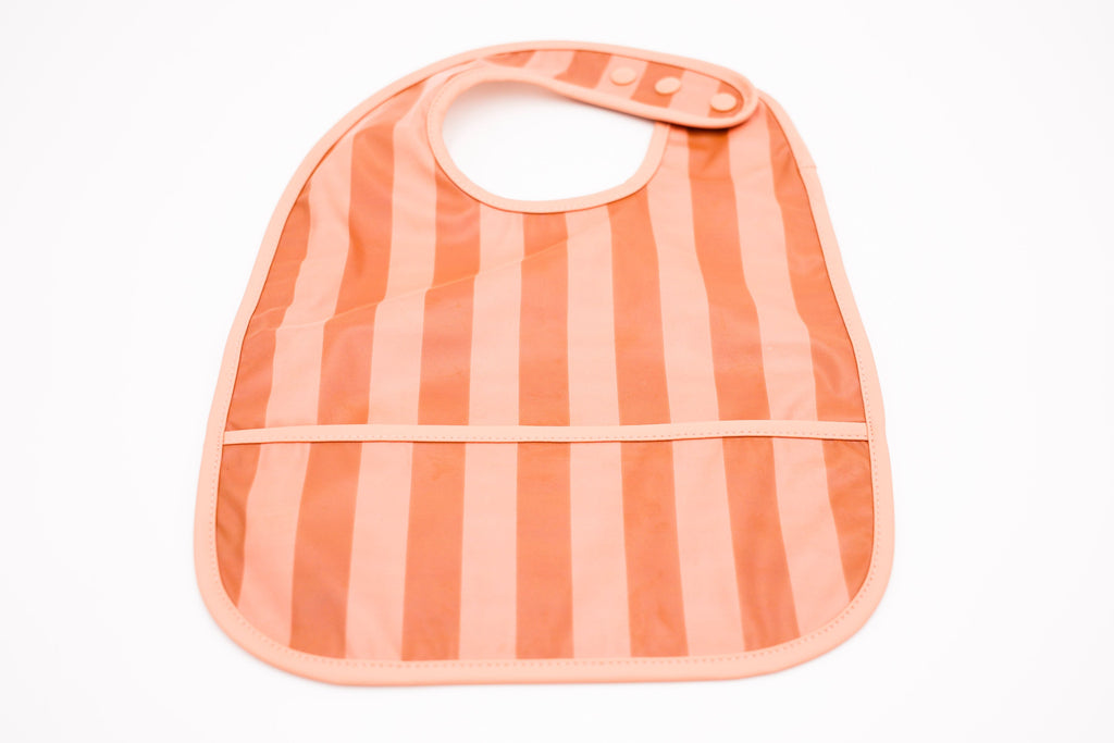 Keep mealtimes cleaner and more fun for all with the Grech & Co. easy-to-clean and store pink bib. Bib with pocket and water-resistant recycled oeko tex material. We love it when practical and stylish come together. Sustainable baby and kids pink food bib, bib for babies. Recycled material baby bib for baby meals.