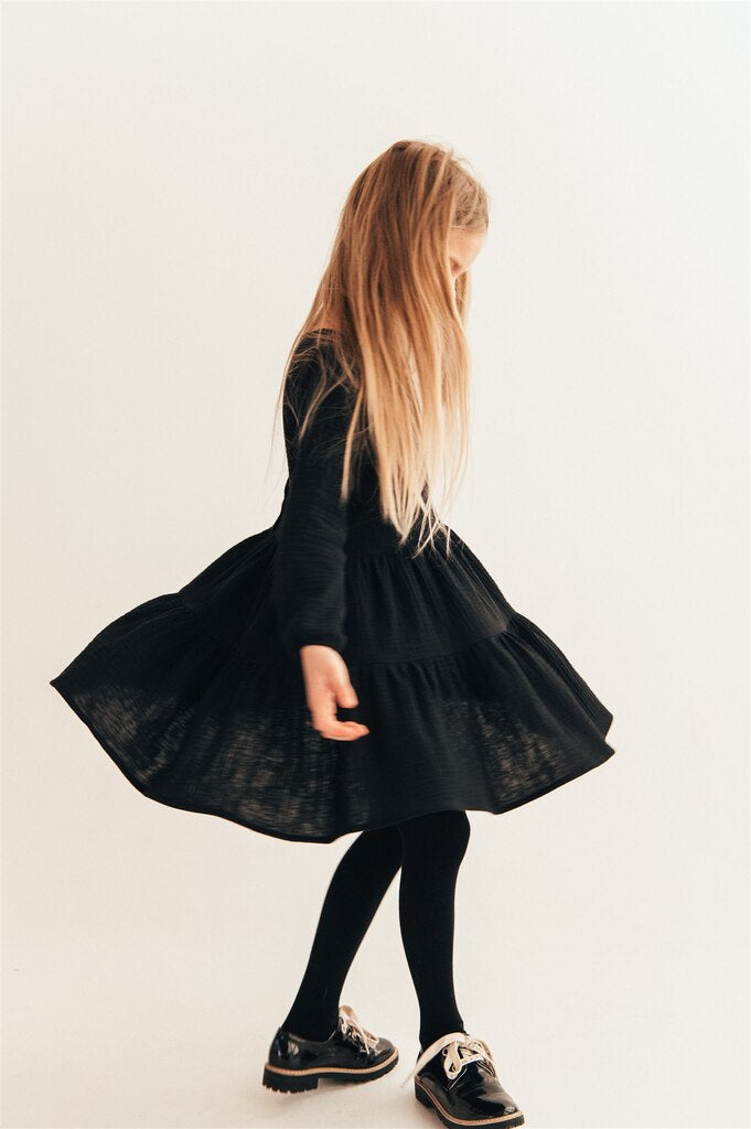 The organic muslin girls long sleeve dress in black color is breathable, comfortable, and easy to wear. Stylish black dress for parties and events with volume and buttons on back.  Milimilu offers kids' clothing, girls' dresses, and girls' fashion online in Hong Kong and Singapore—the best present for girls.