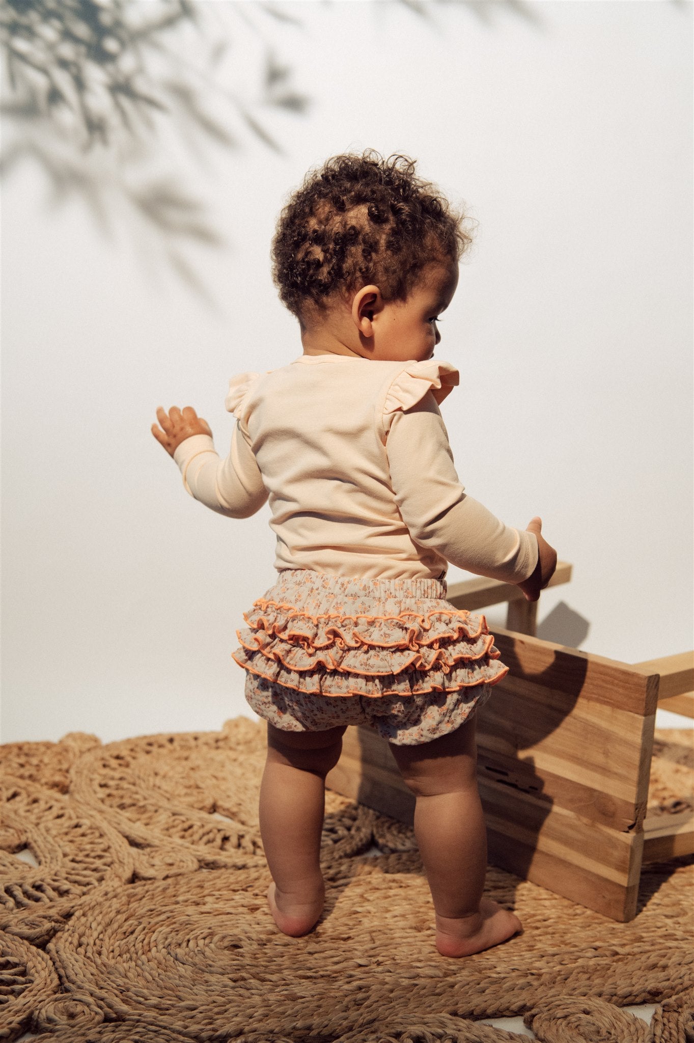 Breathable organic cotton baby girls romper in light pink color with strawberry print and ruffles on the shoulders. The breathable baby clothing online.