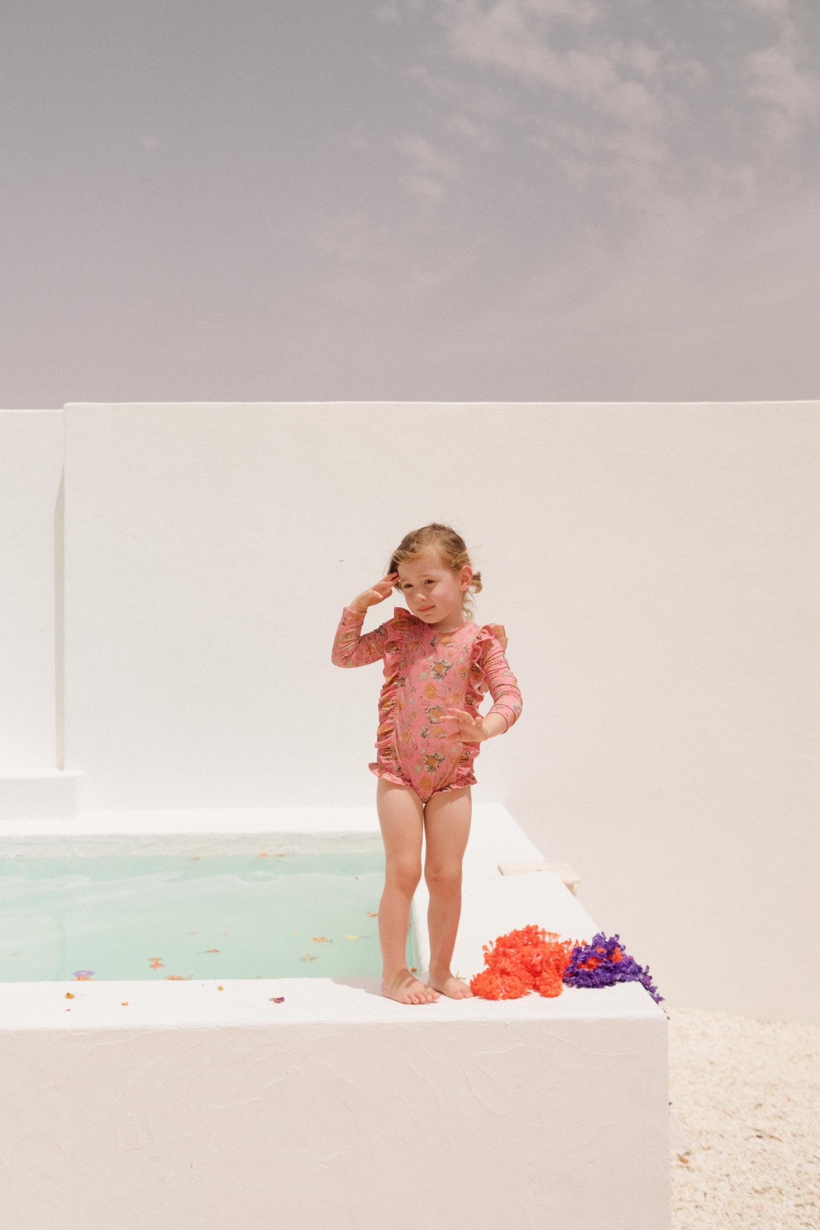 Pink recycled swimsuit is made from an SPF 50 protective fabric covering the entire upper body by Louise Misha. Stylish girls swimsuit with sun protection.