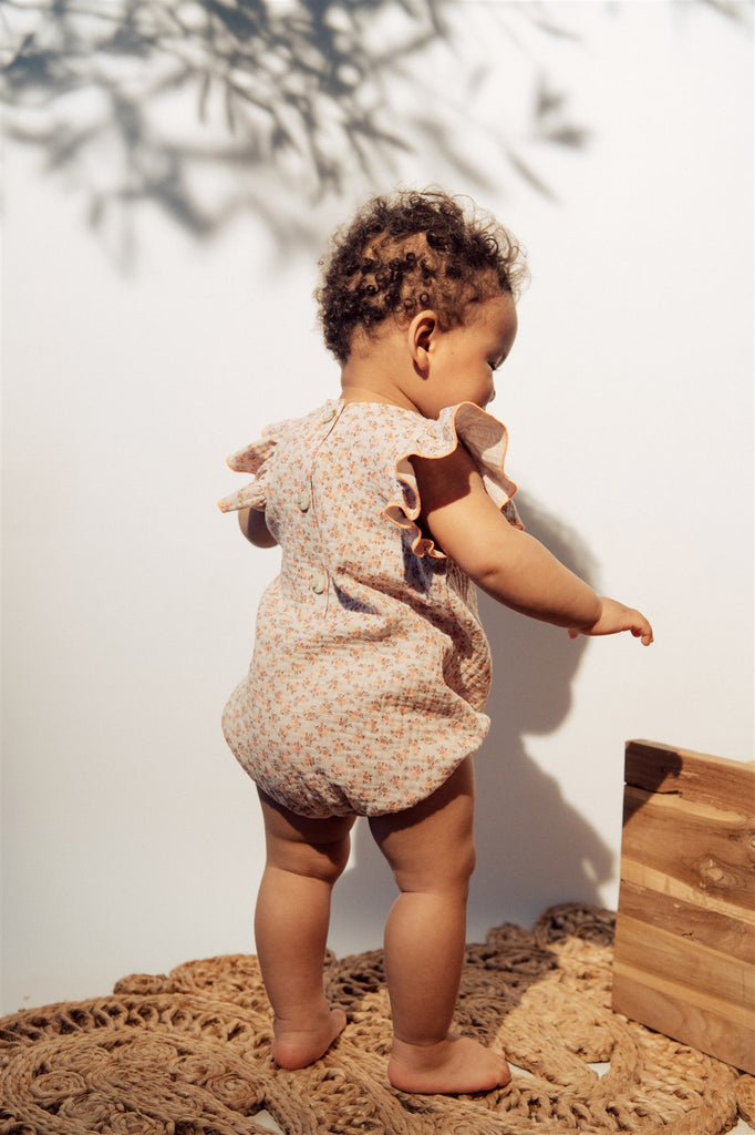 The breathable organic cotton baby girl romper with ruffles and floral print is the most adorable baby girl's outfit. The soft and breathable organic muslin baby girl's romper is perfect for summer. Amazing baby shower gift for baby girls. Milimilu offers sustainable baby clothing from organic cotton in Hong Kong.