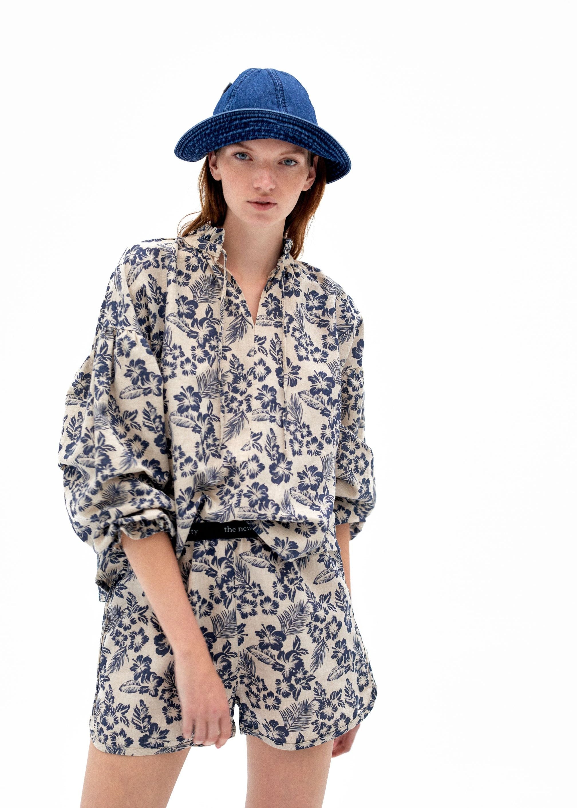 Woman wearing hibiscus print linen shorts, front view showing floral pattern and comfortable fit.